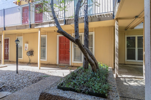 view of exterior entry with a patio and a balcony