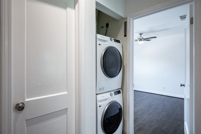 washroom featuring stacked washer / dryer, dark hardwood / wood-style flooring, and ceiling fan