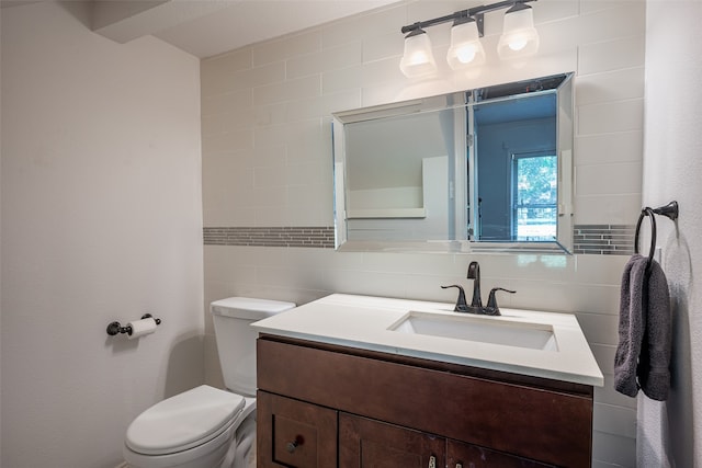 bathroom featuring vanity, tile walls, backsplash, and toilet