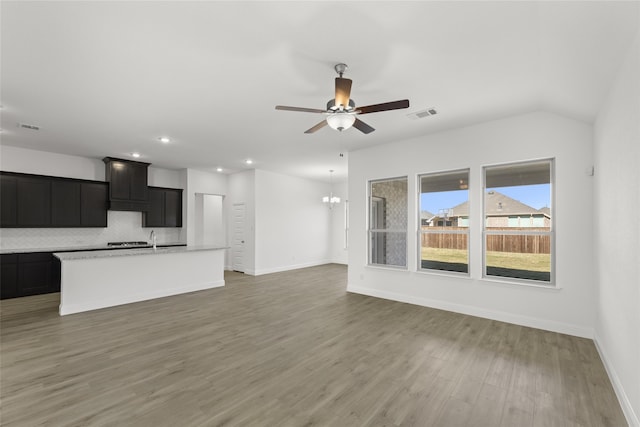 unfurnished living room featuring dark wood-type flooring and ceiling fan with notable chandelier