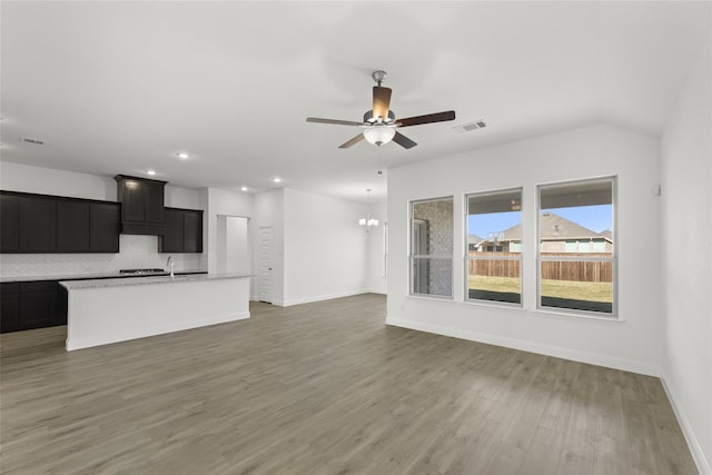 unfurnished living room featuring dark hardwood / wood-style floors and ceiling fan with notable chandelier