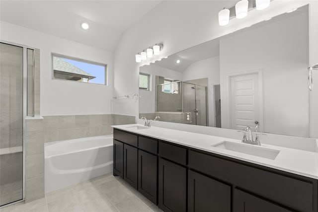 bathroom featuring tile patterned flooring, vanity, vaulted ceiling, and shower with separate bathtub