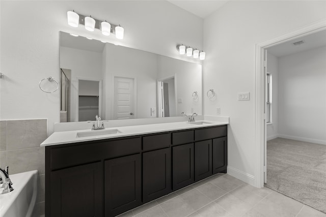 bathroom featuring tile patterned flooring, vanity, and a bath