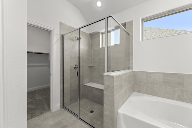 bathroom with plus walk in shower, tile patterned floors, and lofted ceiling