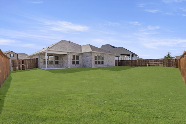 rear view of property featuring a lawn