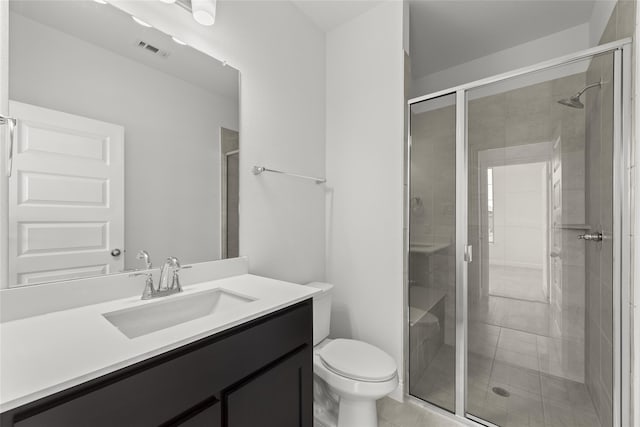 bathroom featuring vanity, a shower with door, and toilet