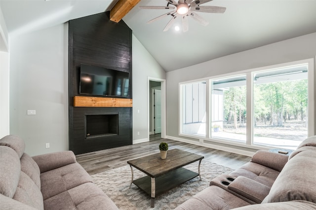 living room with ceiling fan, a large fireplace, light hardwood / wood-style flooring, beamed ceiling, and high vaulted ceiling