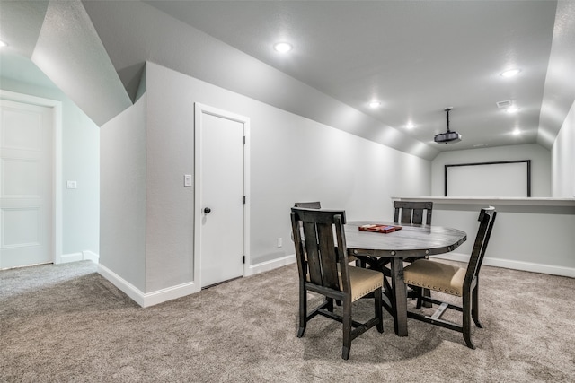 carpeted dining area with lofted ceiling