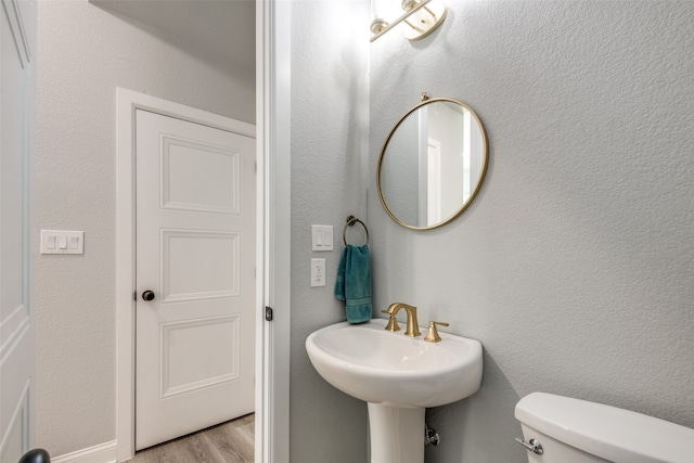 bathroom featuring toilet and wood-type flooring