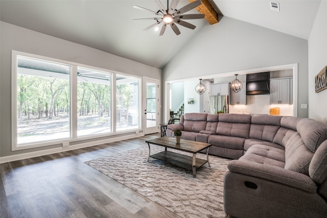 living room featuring beamed ceiling, dark wood-type flooring, and a healthy amount of sunlight