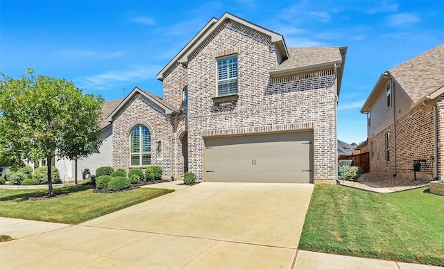 view of property featuring a front yard and a garage