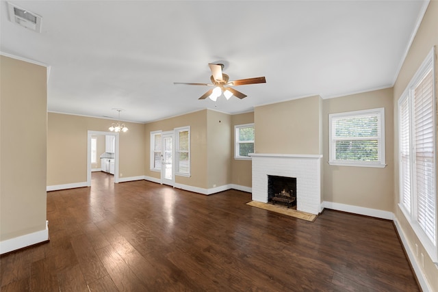 unfurnished living room with ornamental molding, dark wood-type flooring, a fireplace, and ceiling fan with notable chandelier