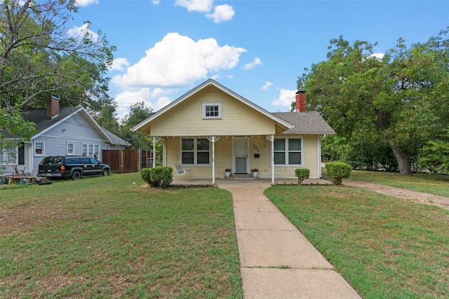 bungalow-style home with a porch and a front lawn