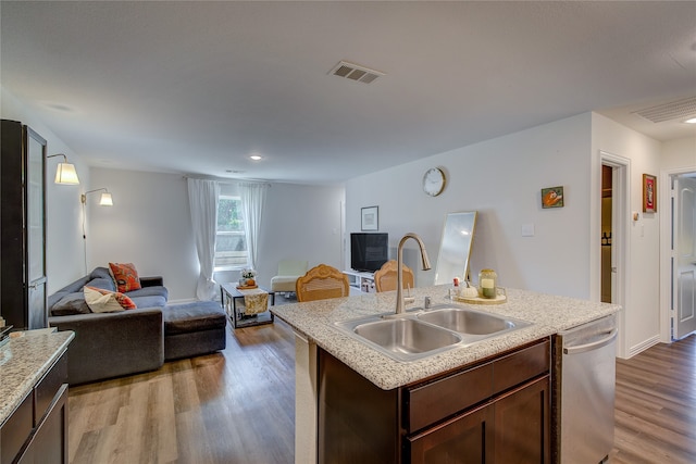 kitchen with light hardwood / wood-style flooring, dishwasher, a center island with sink, and sink