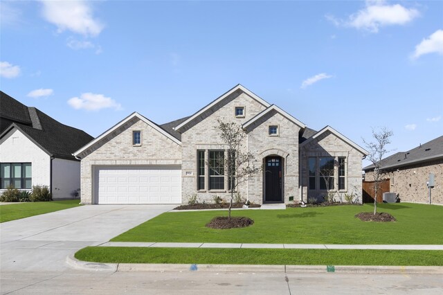 french provincial home with a garage, central AC unit, and a front yard