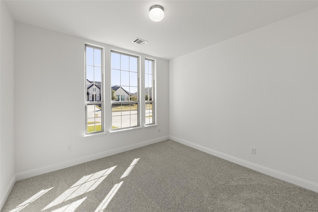 carpeted spare room featuring a healthy amount of sunlight