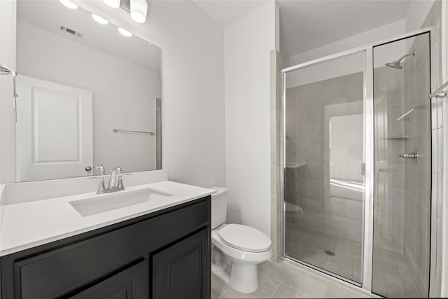 bathroom with tile patterned floors, vanity, toilet, and a shower with shower door