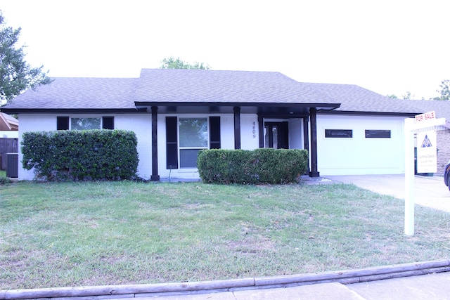 view of front of property with a front yard and a garage