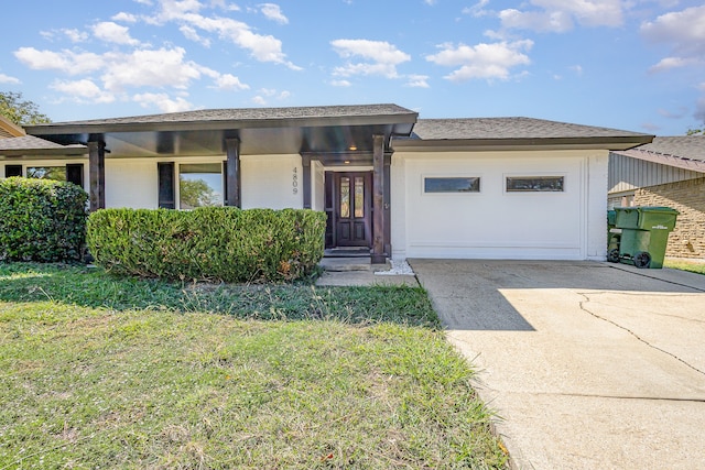 view of front of property featuring a front yard, a garage, and covered porch