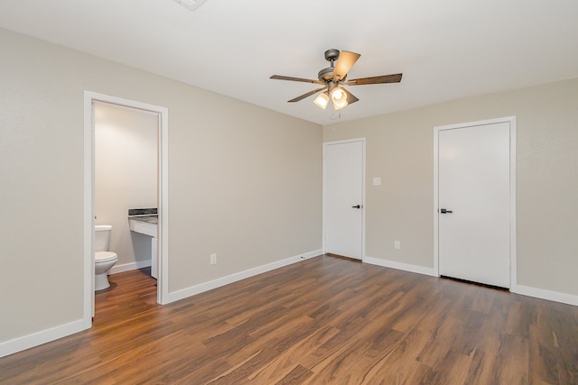 unfurnished bedroom featuring ensuite bath, ceiling fan, and dark hardwood / wood-style floors