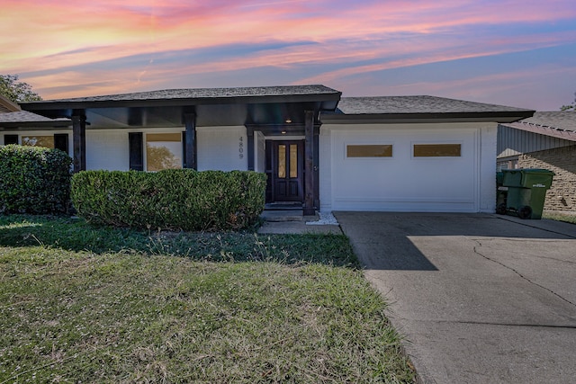 view of front of property with a yard and a garage