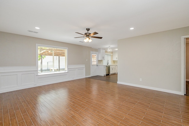 unfurnished living room featuring light hardwood / wood-style floors, ceiling fan, and sink