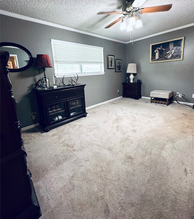 sitting room featuring a textured ceiling, ceiling fan, carpet flooring, and crown molding