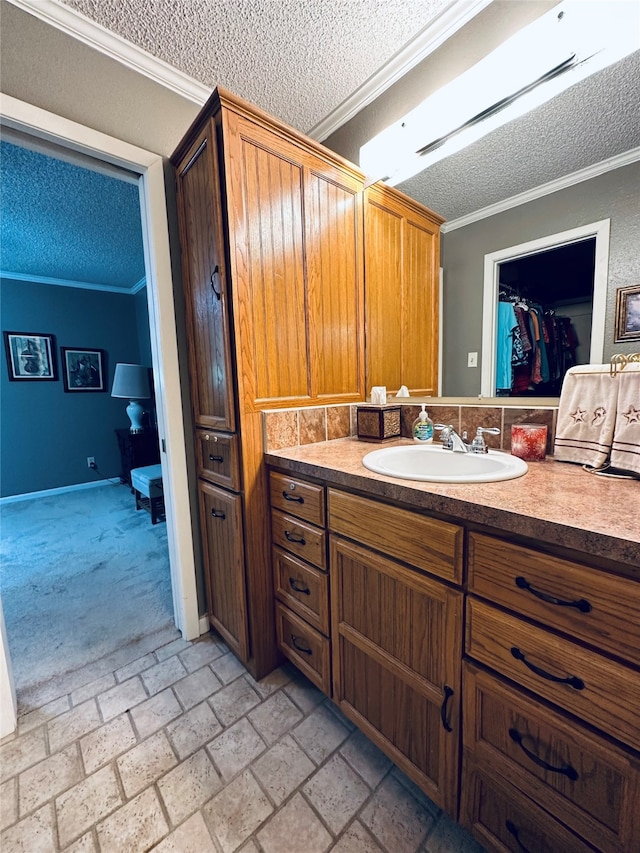 bathroom with vanity, a textured ceiling, and ornamental molding