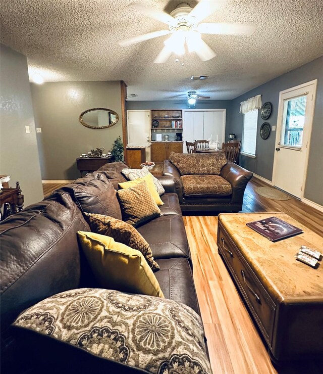 1402 Marie St N, Comanche, TX 76442 - living room with ceiling fan, light wood-style floors, and a textured ceiling