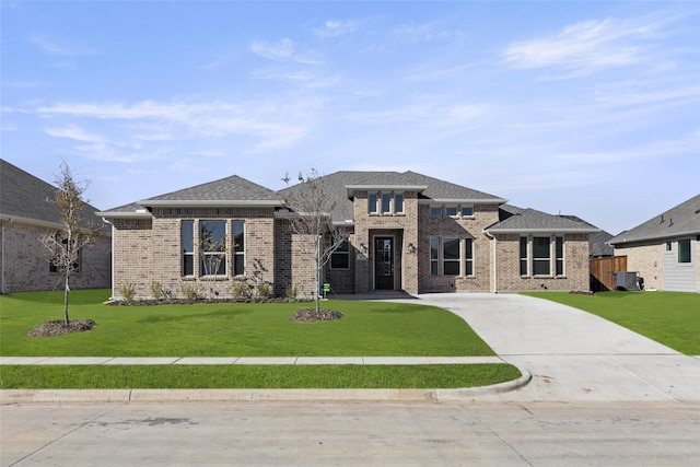 912 Guava Ct, Forney, TX 75126 - prairie-style house featuring brick siding, a front lawn, cooling unit, and driveway