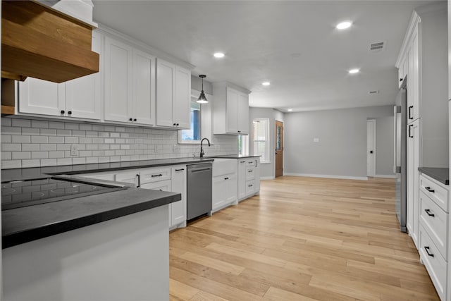 kitchen with white cabinets, dishwasher, light hardwood / wood-style floors, and decorative light fixtures