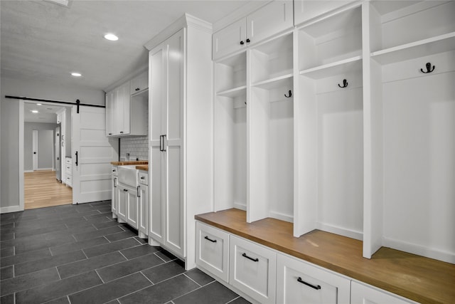 mudroom with dark hardwood / wood-style flooring and a barn door