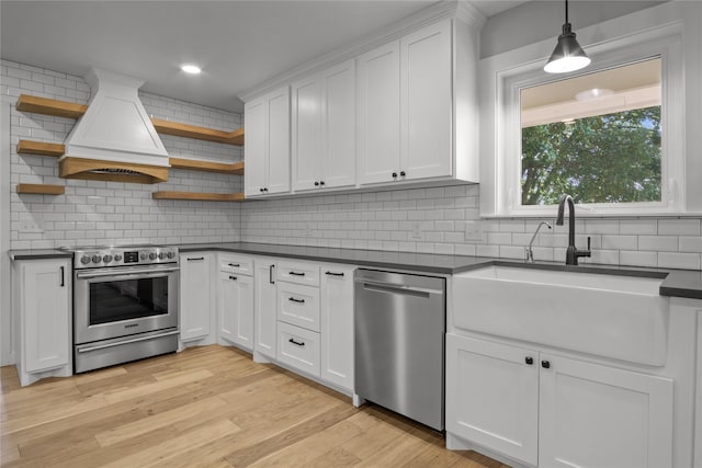 kitchen with stainless steel appliances, white cabinetry, light hardwood / wood-style floors, and sink