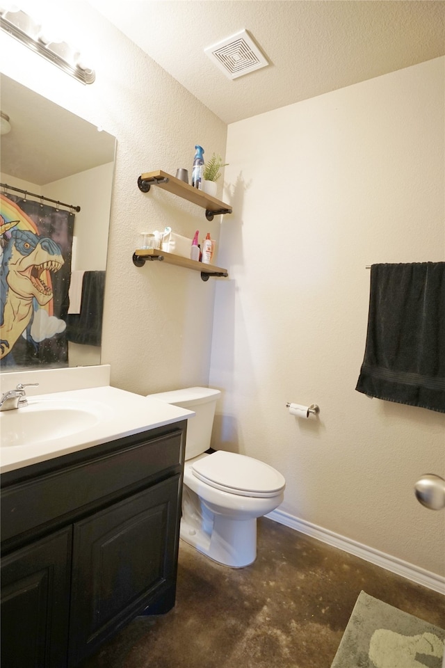 bathroom featuring a textured ceiling, vanity, and toilet