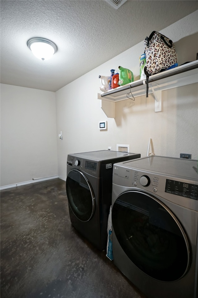 clothes washing area with a textured ceiling and independent washer and dryer