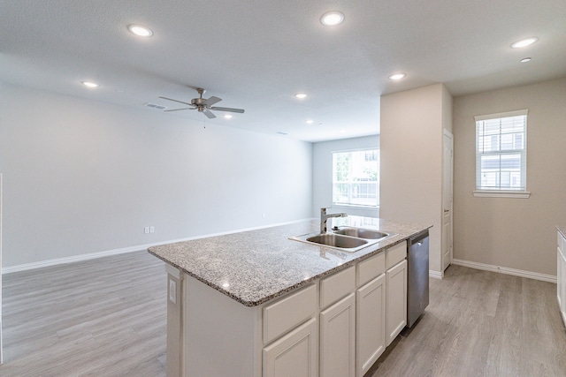 kitchen featuring dishwasher, a kitchen island with sink, sink, light hardwood / wood-style flooring, and ceiling fan