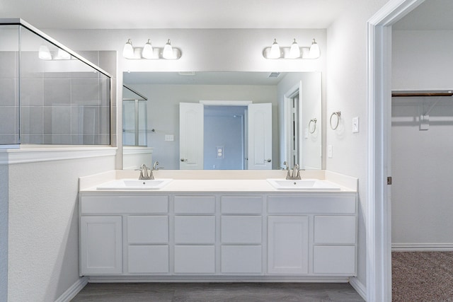 bathroom featuring wood-type flooring, vanity, and a shower with shower door