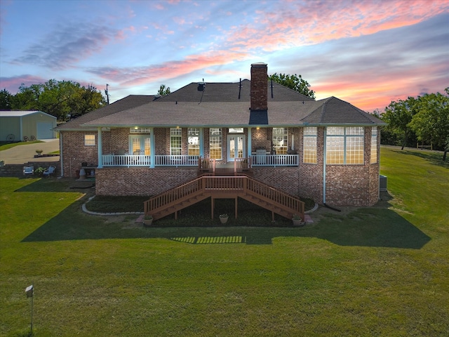 back house at dusk featuring a yard