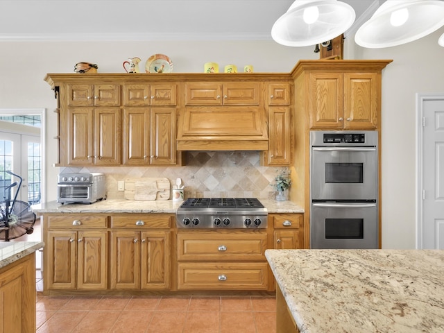 kitchen featuring tasteful backsplash, appliances with stainless steel finishes, light tile patterned floors, and pendant lighting