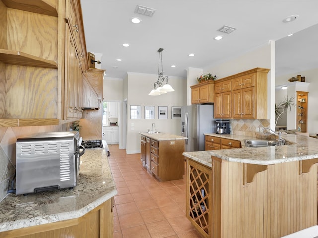 kitchen with kitchen peninsula, stainless steel refrigerator with ice dispenser, sink, and a breakfast bar