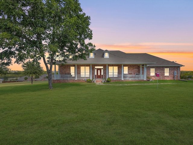 view of front of house featuring covered porch and a lawn