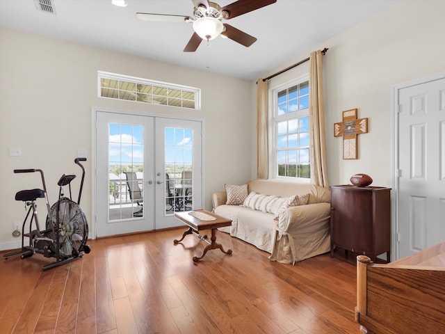 sitting room featuring french doors, light wood-type flooring, and ceiling fan