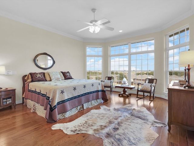 bedroom with crown molding, hardwood / wood-style flooring, and ceiling fan