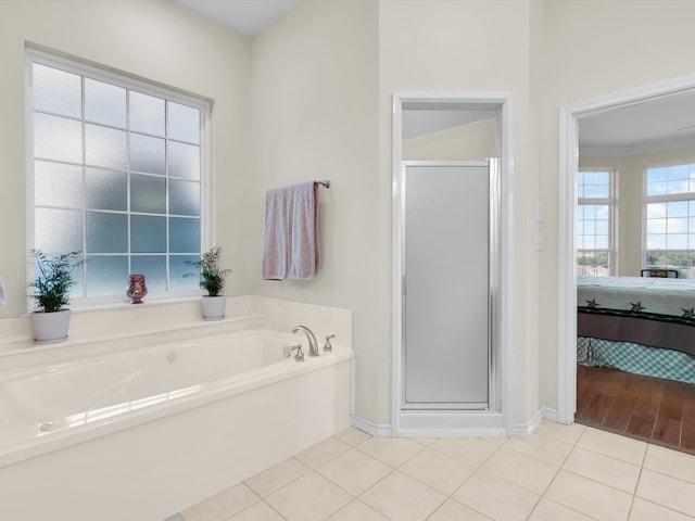 bathroom with tile patterned floors and shower with separate bathtub