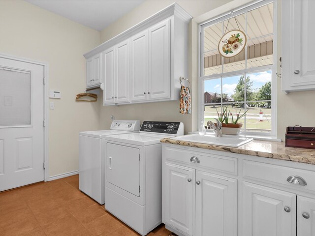 laundry room featuring sink, light tile patterned floors, cabinets, and washer and clothes dryer