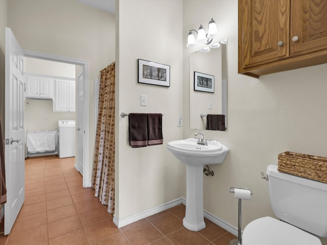 bathroom with washer / dryer, tile patterned floors, and toilet