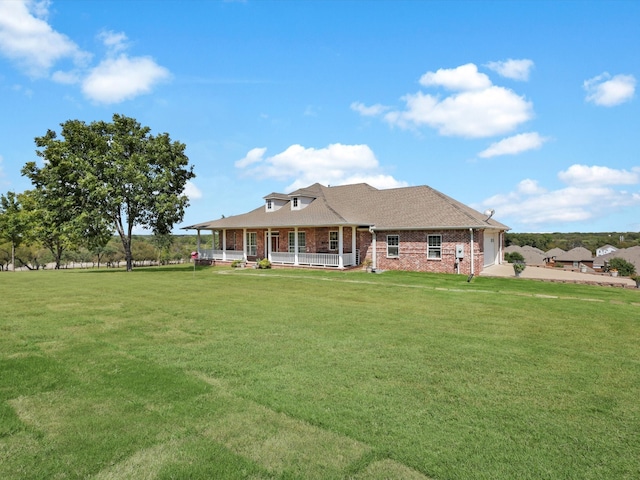 view of front of home featuring a front yard, covered porch, and a garage