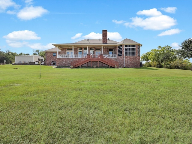 rear view of house featuring a yard and a deck