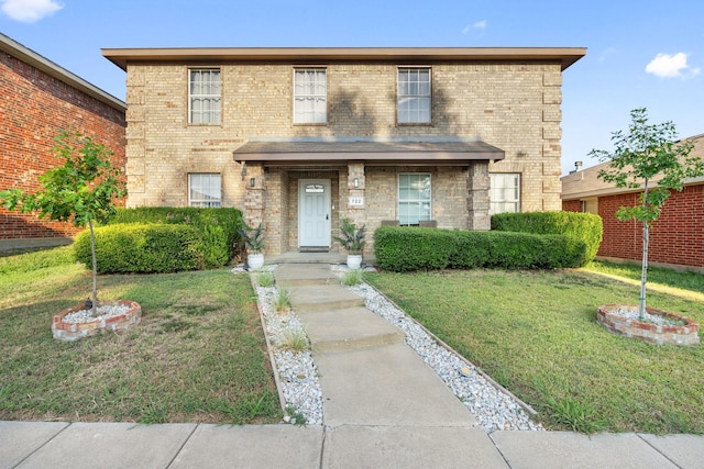 view of front of house featuring brick siding and a front lawn