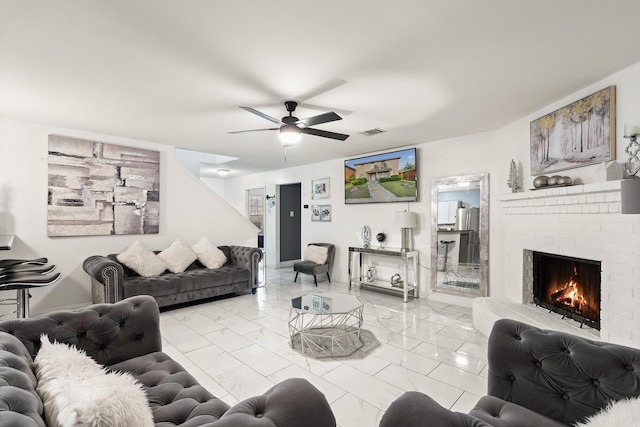 living room featuring a brick fireplace and ceiling fan